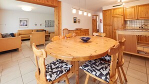 A dining area with a round wooden table and six chairs, each with patterned cushions. - Grand Vue 01-02 by Interhome (Thyon-Les Collons)