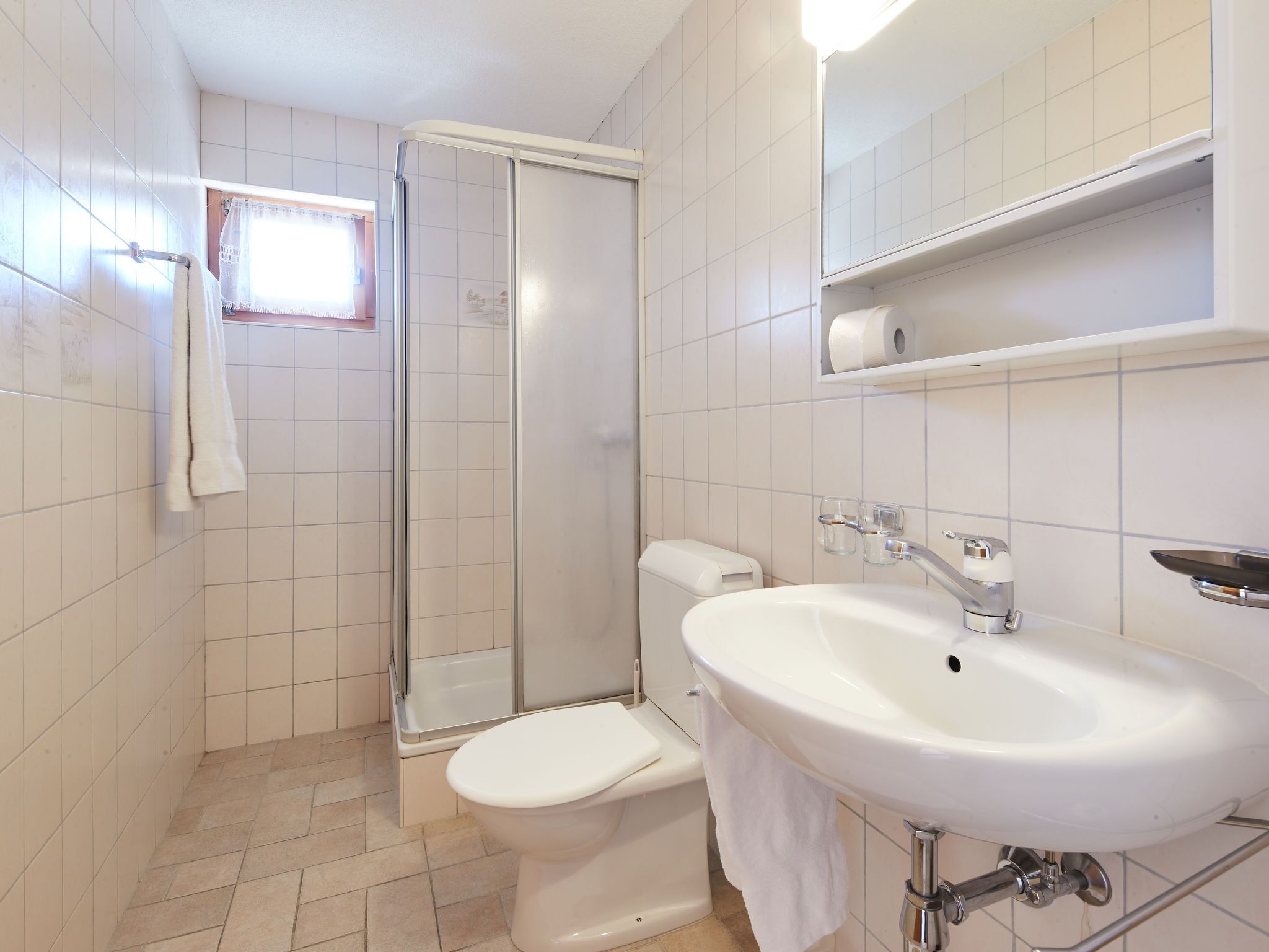 Ein modernes Badezimmer mit Toilette, Waschbecken und Dusche.