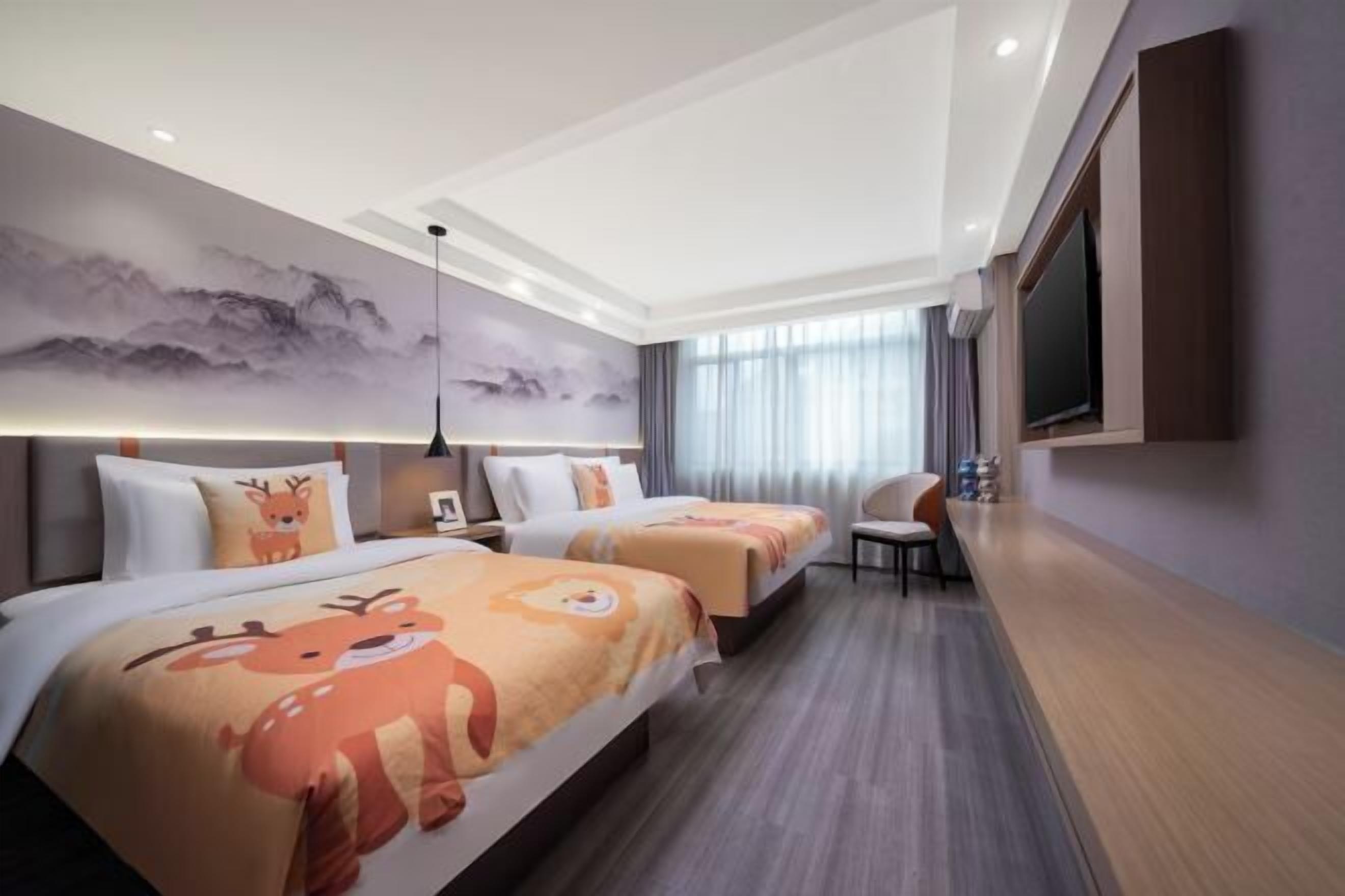Une chambre d’hôtel avec deux lits, une télévision, un bureau et une chaise.