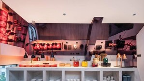 A modern kitchen with a marble countertop, built-in shelves, and a variety of kitchenware. - CEO· Lan Hotel (Yiwu)