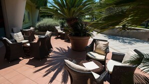 An outdoor seating area with wicker chairs and a large potted plant. - Chic double room near the Bibione coast (Bibione)