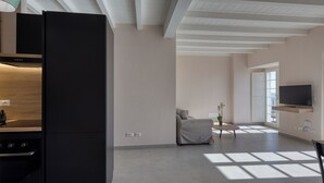 Une cuisine moderne dotée d’un four encastré et d’un grand réfrigérateur noir.