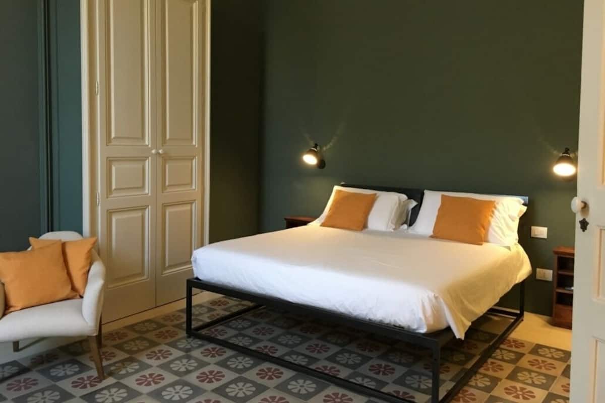 Une chambre à coucher avec un lit, une chaise et une armoire.