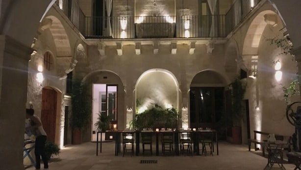 A spacious courtyard with a dining area, arched ceilings, and a balcony overlooking the space. - PALAZZO GARZIA - Dimora Storica (Maglie)