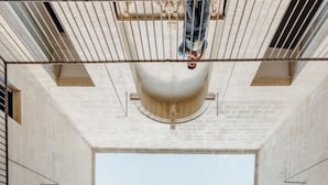 A high-ceilinged atrium with a central skylight, stone walls, and a wooden floor. - PALAZZO GARZIA - Dimora Storica (Maglie)
