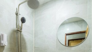 A bathroom with a shower, a sink, and a mirror.