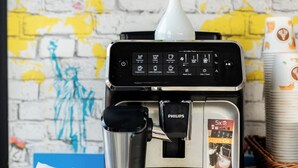 A coffee machine with a digital display, a plant, and a tissue box.