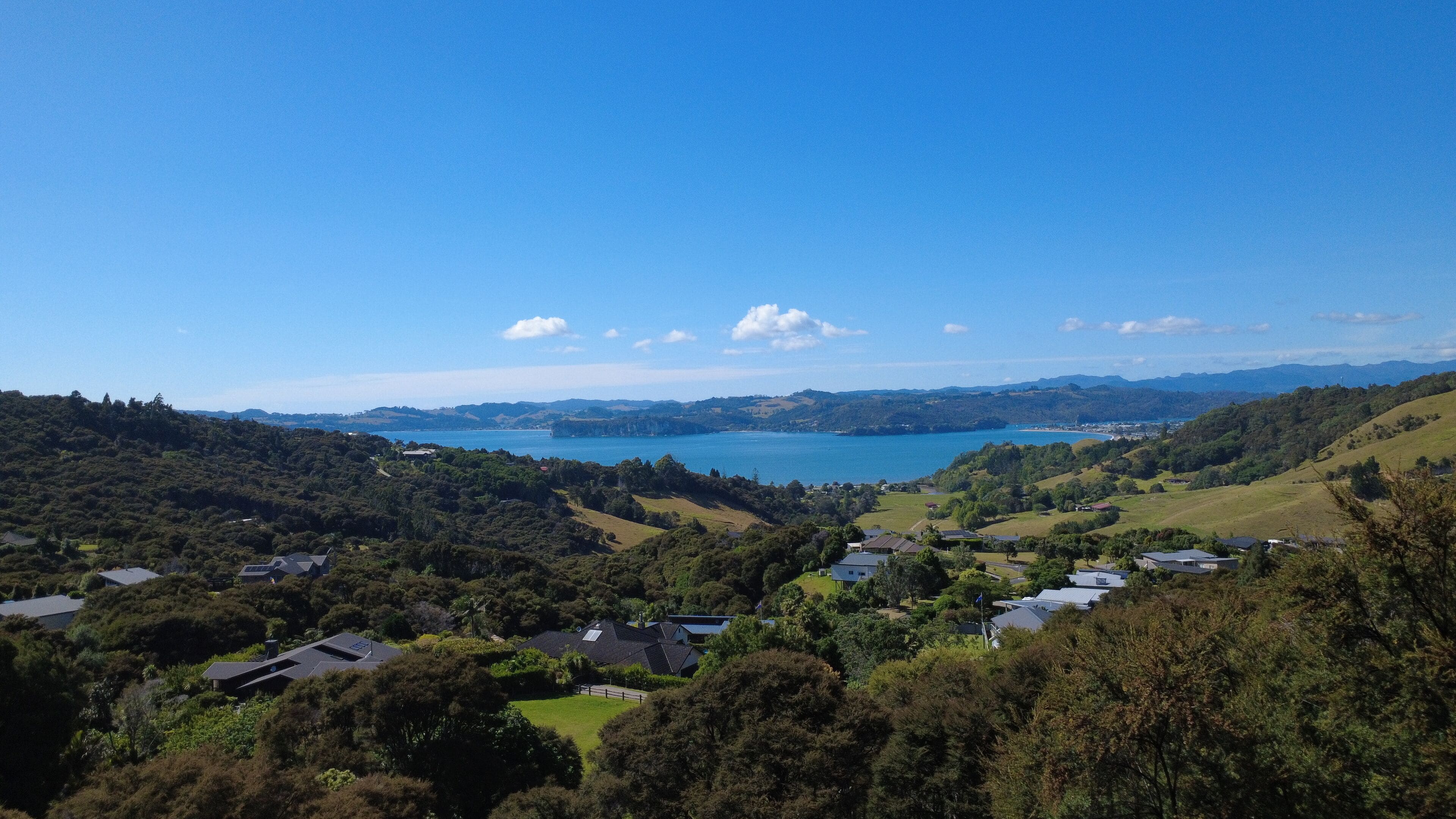 A scenic view of a coastal area with houses and a large body of water.