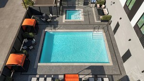 An aerial view of a rooftop swimming pool with lounge chairs and a small seating area. - Fairfield by Marriott Inn & Suites Chilliwack (CHILLIWACK)