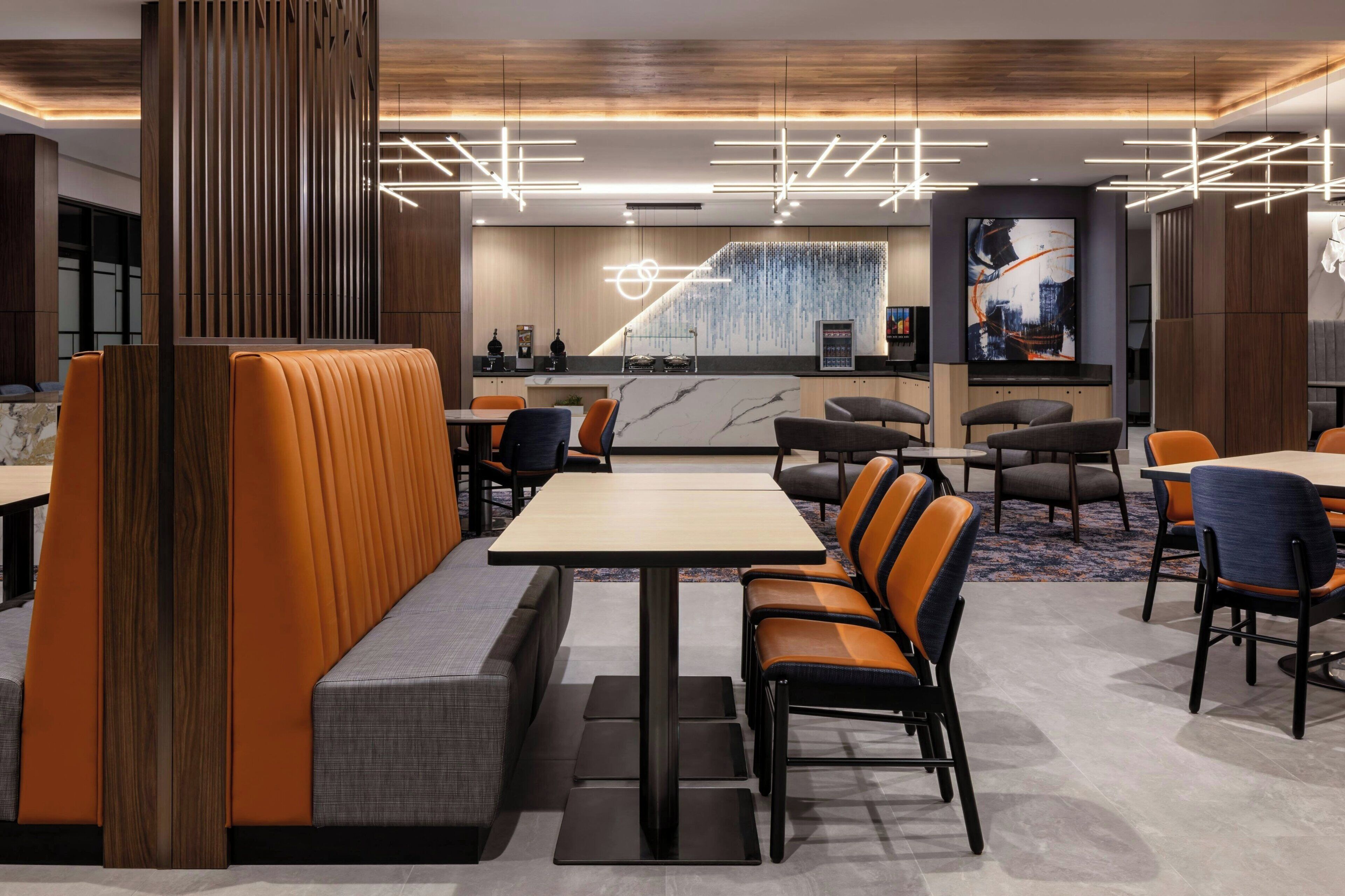 A modern restaurant with booths, high tables, and a central bar area.