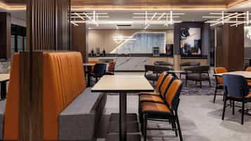 A modern restaurant with booths, high tables, and a central bar area.
