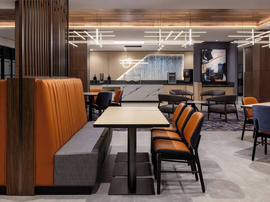 A modern restaurant with booths, high tables, and a central bar area.