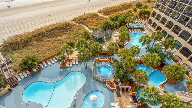 A resort with multiple swimming pools, lounge areas, and a beach view. - Oceanfront Retreat with Private Balcony (North Myrtle Beach)
