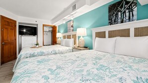 A hotel room with two beds, a bathroom, a TV, and a painting of a pier. - Oceanfront Retreat with Private Balcony (North Myrtle Beach)