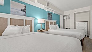 A hotel room with two beds, a nightstand with a lamp, a wardrobe, and artwork on the walls. - Panoramic Ocean View, Lazy River (North Myrtle Beach)