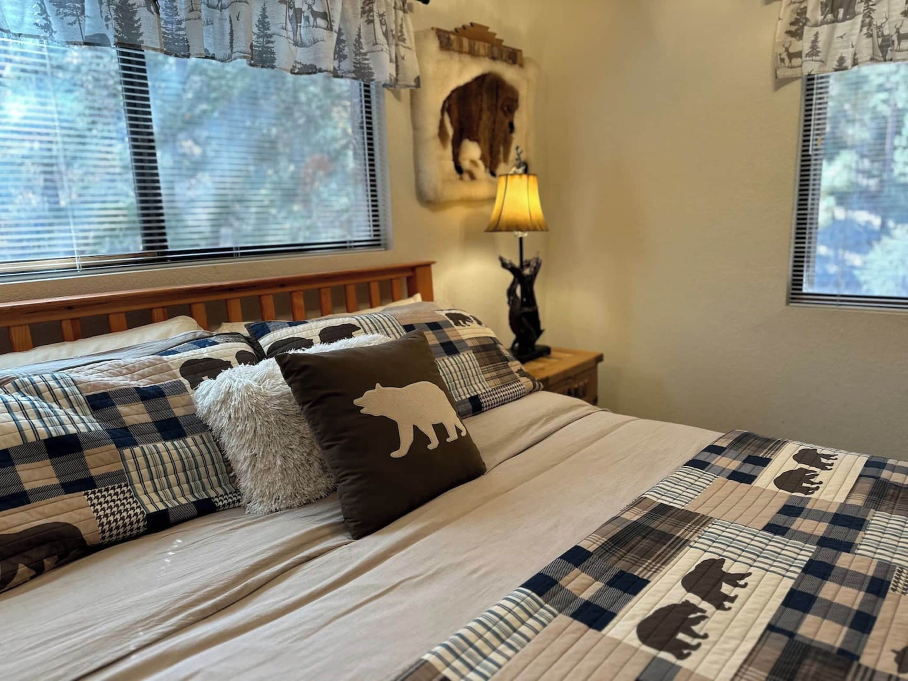 A bedroom with a bed, a nightstand, a lamp, and a wall-mounted artwork.