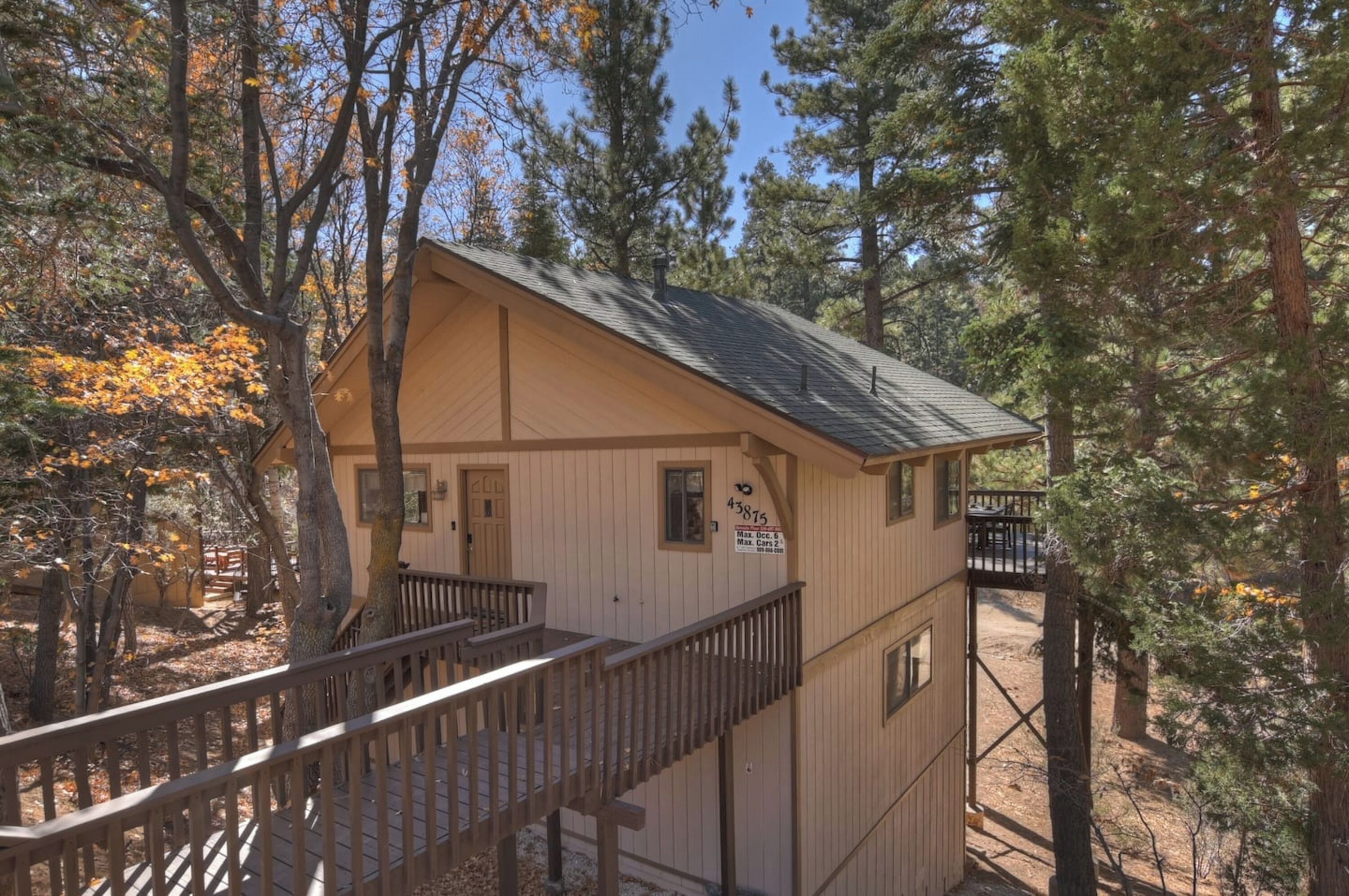 A small cabin with a wooden deck and stairs leading to a porch.