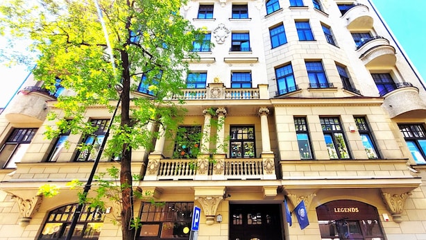 A historic building with classical architecture, featuring columns, ornate balconies, and large windows. - Central Station Hostel (Warsaw)