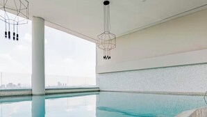 A modern indoor swimming pool with a clear view of the city skyline. - Apartment in plaza pabellon zone andares (Guadalajara)