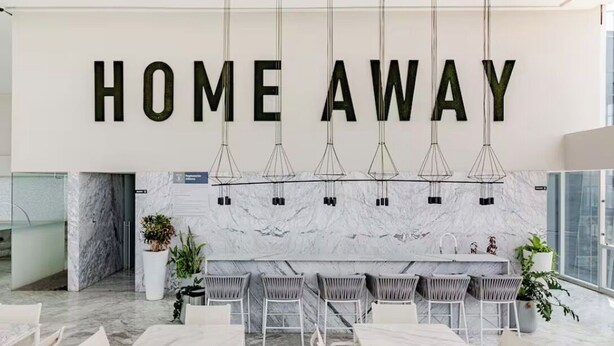 A modern interior with a 'HOME AWAY' sign, marble flooring, and a dining area with white furniture. - Apartment in plaza pabellon zone andares (Guadalajara)