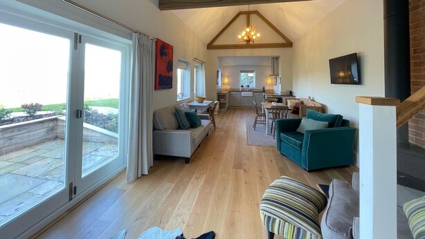A spacious living area with a high ceiling, large windows, and a view of the outdoors. - Charming countryside retreat (Cross in Hand)