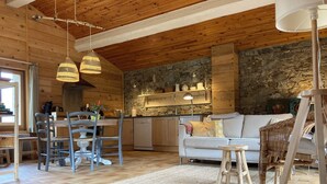Interior acogedor de una cabaña con comedor, cocina y zona de estar.