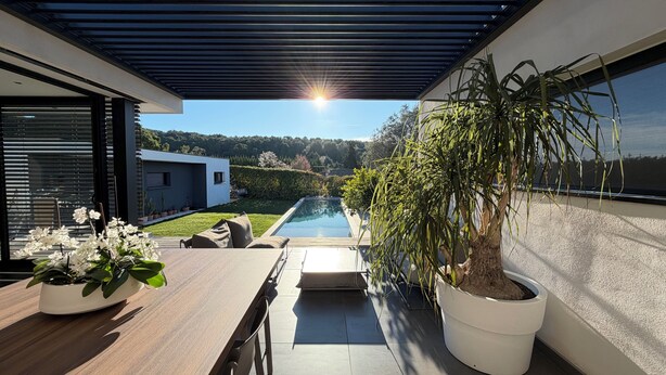 A modern outdoor patio with a pool, potted plants, and a view of a modern house. - L'Ecrin contemporain (Nages-et-Solorgues)