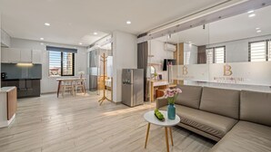 A modern apartment with a kitchen, dining area, and living room. - Ben's House Boutique (Da Nang)
