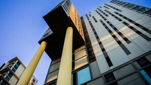 Un immeuble moderne de grande hauteur, doté d’une conception architecturale originale, caractérisé par une structure verticale imposante et de grandes fenêtres.
