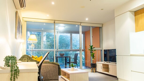 Un salon moderne avec un canapé, une table basse et un téléviseur.