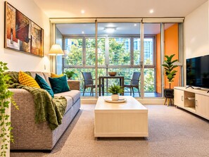 Un salon moderne avec un canapé, une table basse et un téléviseur.