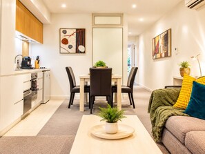 Una cocina moderna con comedor, un sofá y una mesa de centro con una planta.