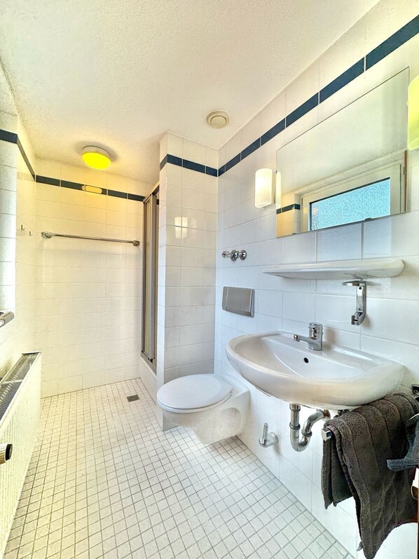 Un baño moderno con ducha, inodoro y lavabo.