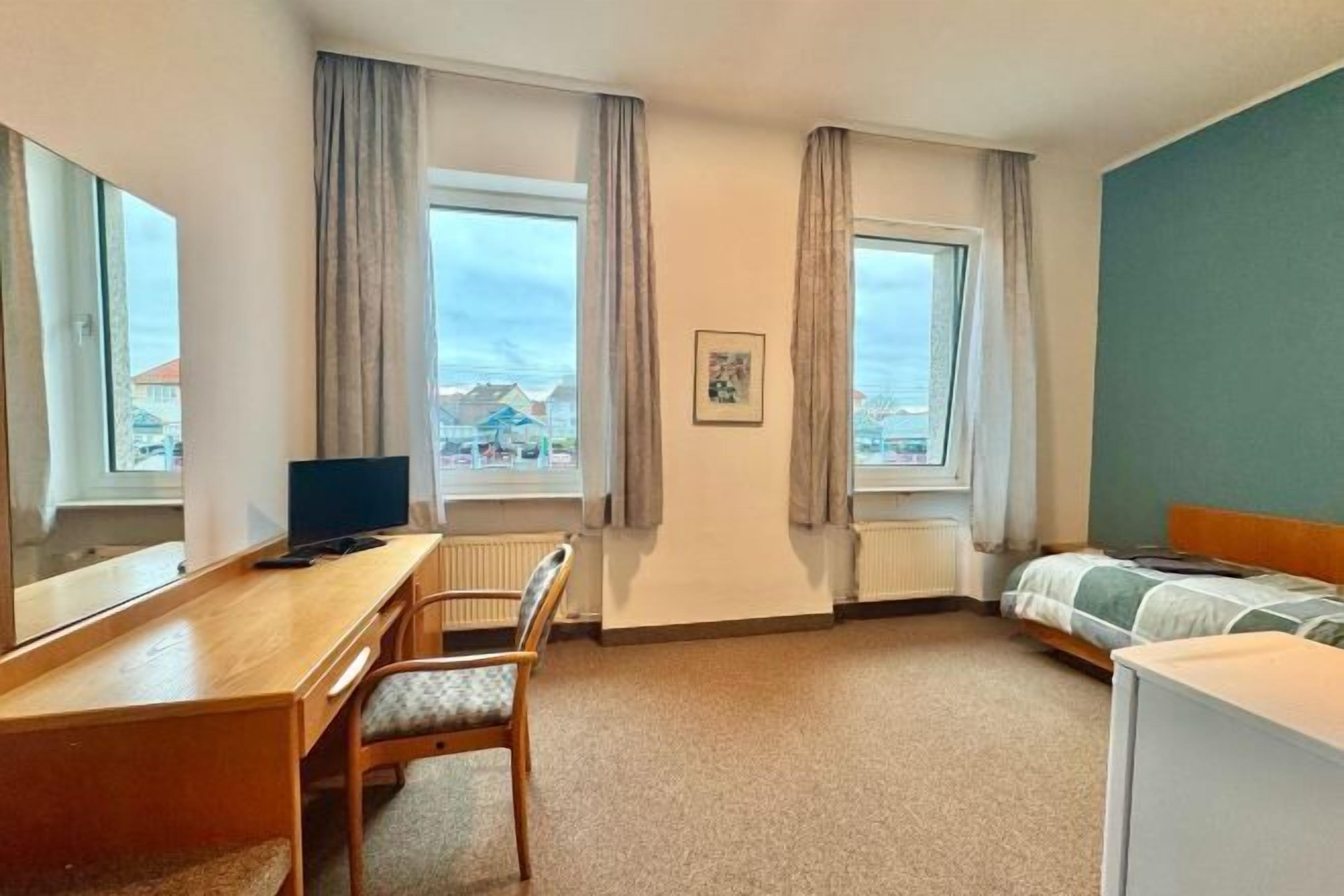 Een bureau, een laptopwerkplek, gratis wifi, beddengoed