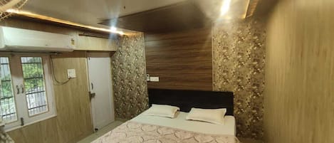 A bedroom with a bed, wooden paneling, and a window with bars.