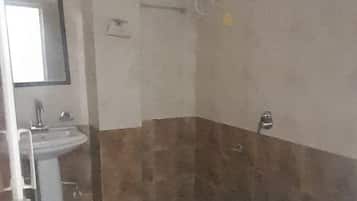 A bathroom with a sink, toilet, shower, and a ceiling-mounted water heater.