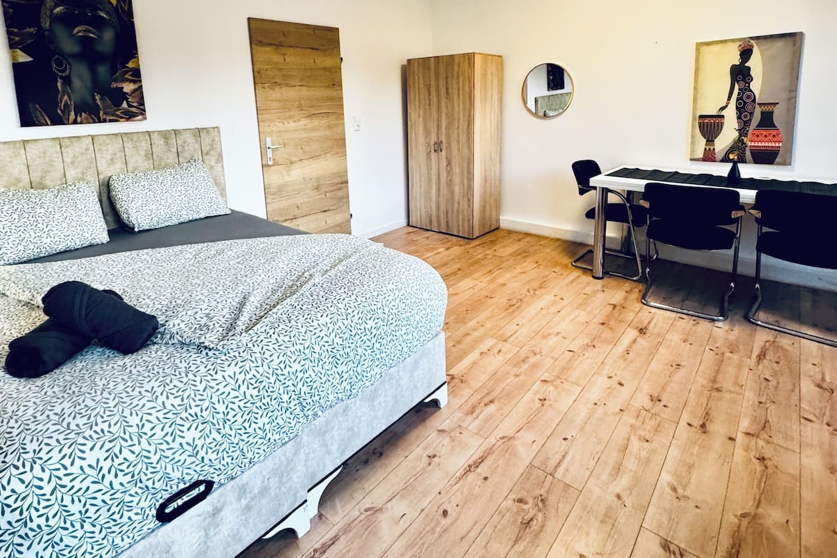 Een moderne slaapkamer met een bed, een bureau en een stoel.