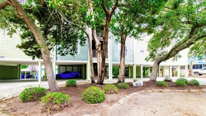 A residential area with a two-story house, a blue car parked in the driveway, and a sign with the number 301. - Blue Wave Retreat in Heart of Myrtle Beach (Myrtle Beach)