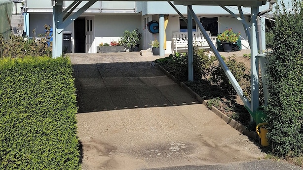 A two-story building with a flat roof and a balcony on the upper floor. - The vacation apartment close to nature invites you to experience a vacation in the heart of nature (Ruderting)