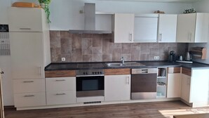 A modern kitchen with a built-in oven, a dishwasher, and a stove. - The vacation apartment close to nature invites you to experience a vacation in the heart of nature (Ruderting)