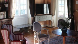 Una sala de estar con chimenea, televisor, estantería y comedor.