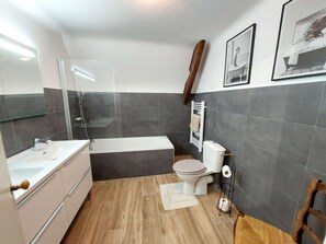 Ein modernes Badezimmer mit Badewanne, Toilette und Waschtisch.