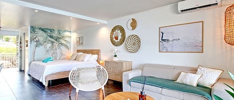 A modern bedroom with a bed, a sofa, a round wooden table, and a large window.
