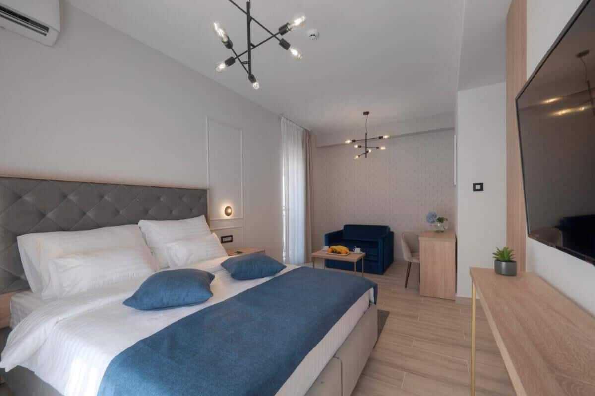 Un dormitorio moderno con una cama grande, un escritorio y un televisor.