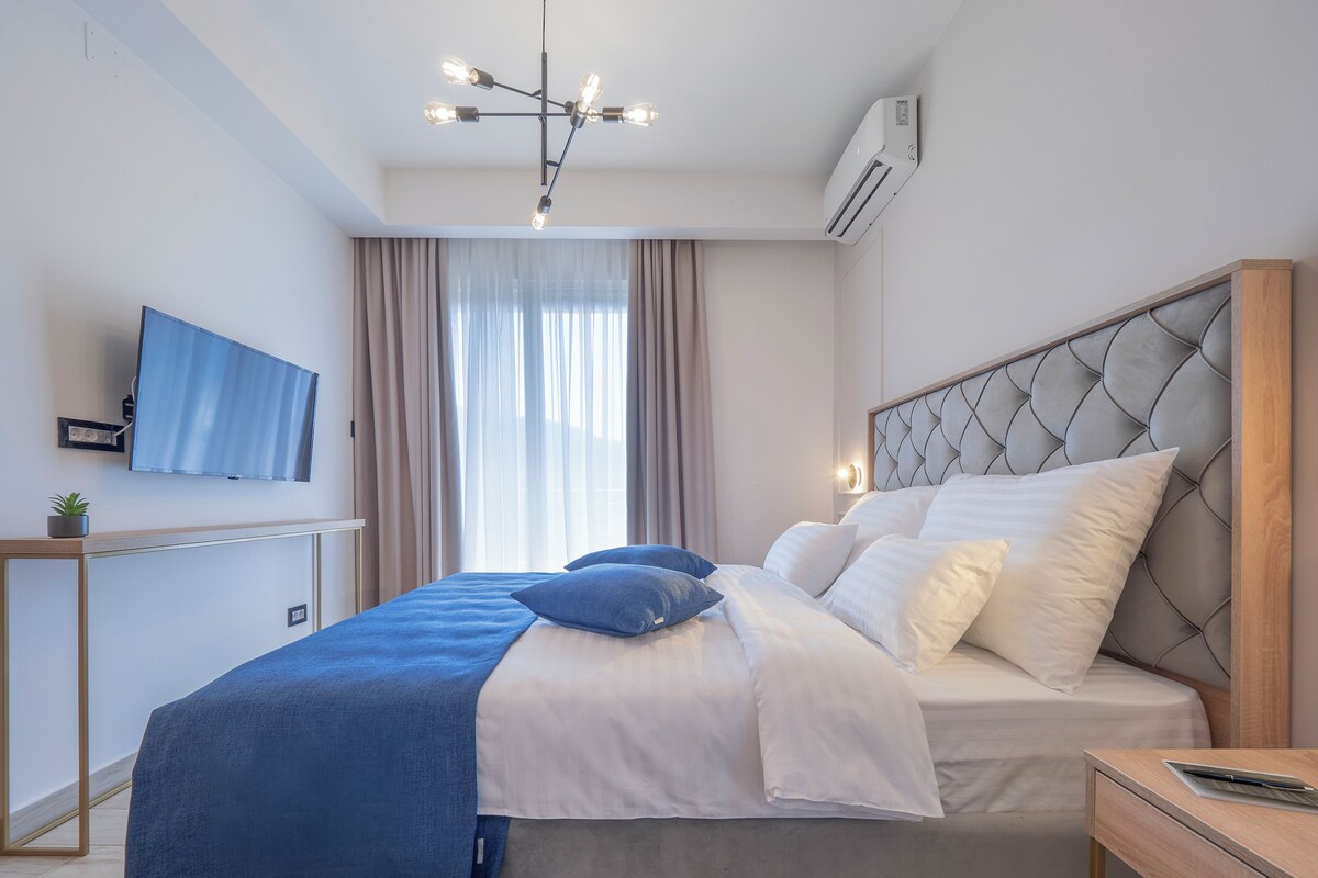 Une chambre moderne équipée d’un lit, d’une table de chevet, d’un téléviseur et d’un appareil de climatisation.