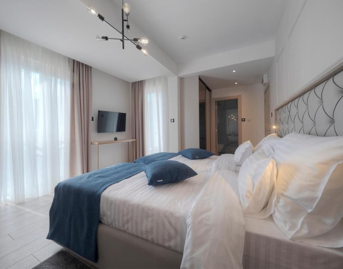 Quarto moderno com uma cama grande, televisão e design exclusivo de cabeceira.
