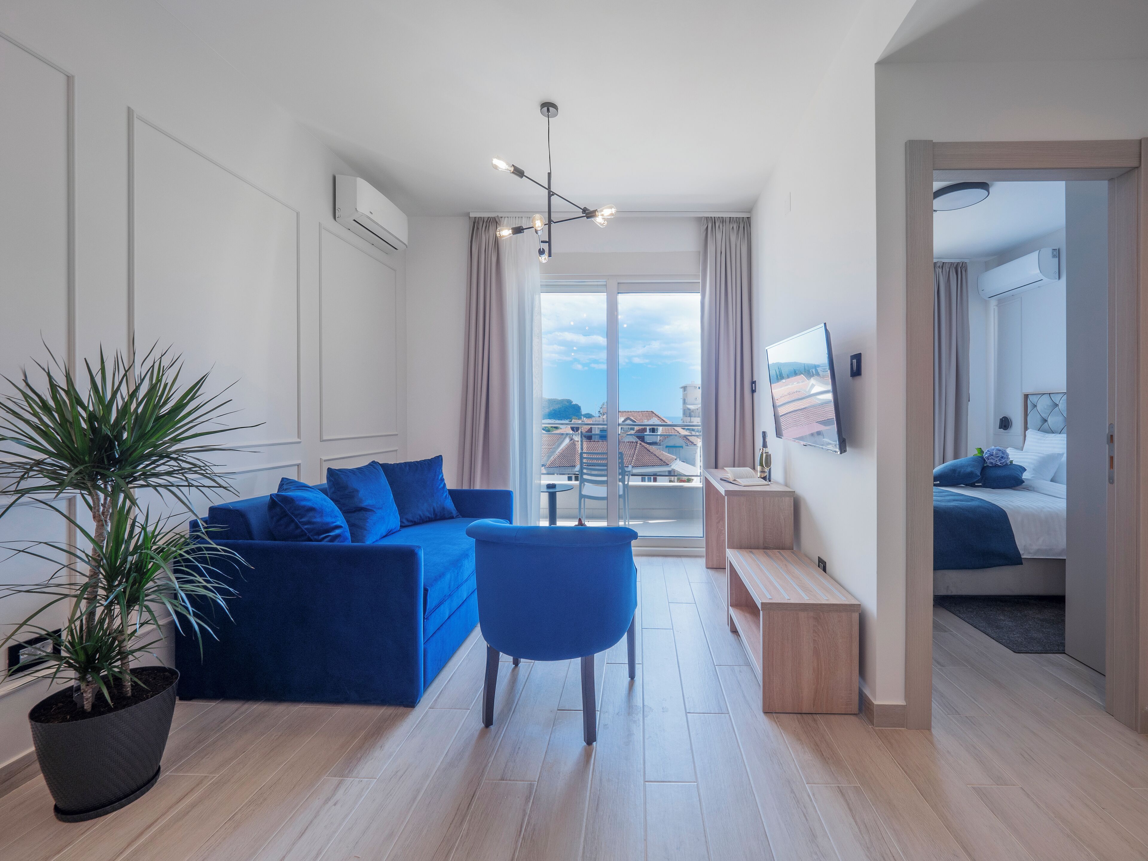 Una sala de estar moderna con un sofá azul, una mesa de centro y una planta en maceta.