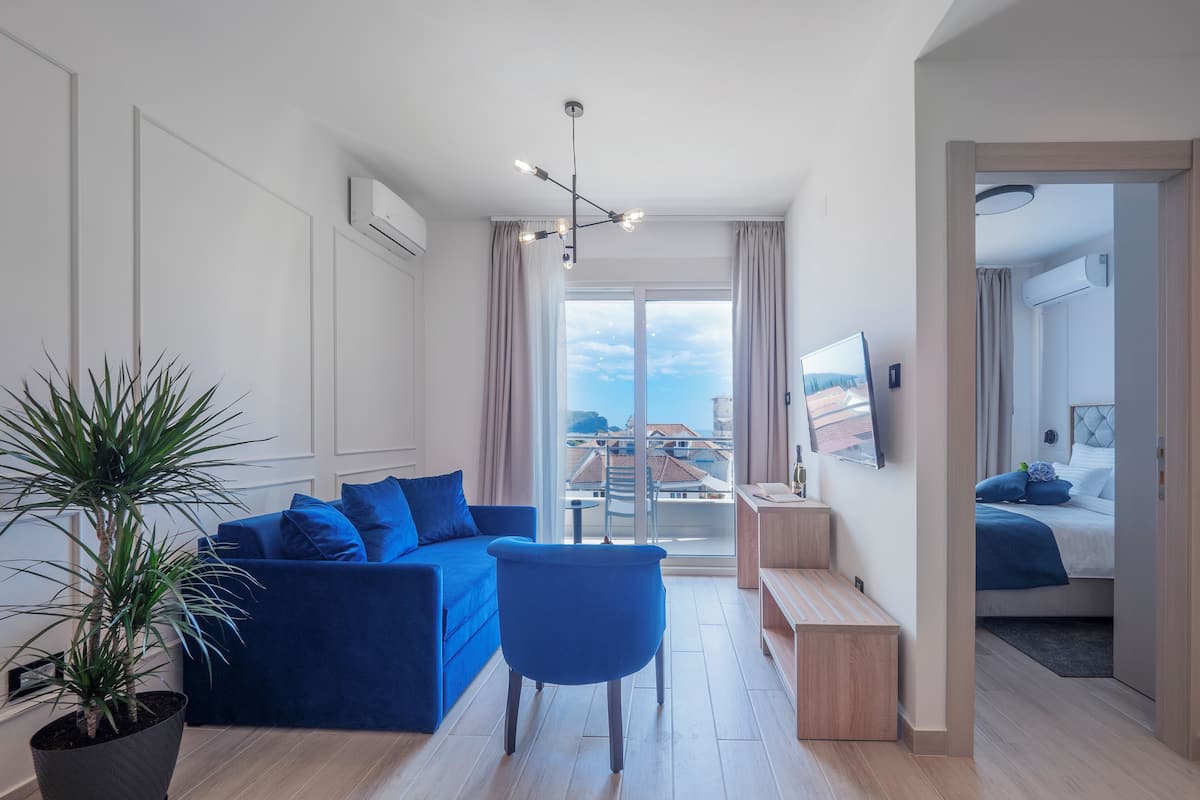 Una sala de estar moderna con un sofá azul, una mesa de centro y una planta en maceta.