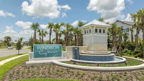 A sign for the Windsor Cay Resort with a central water feature and palm trees in the background.