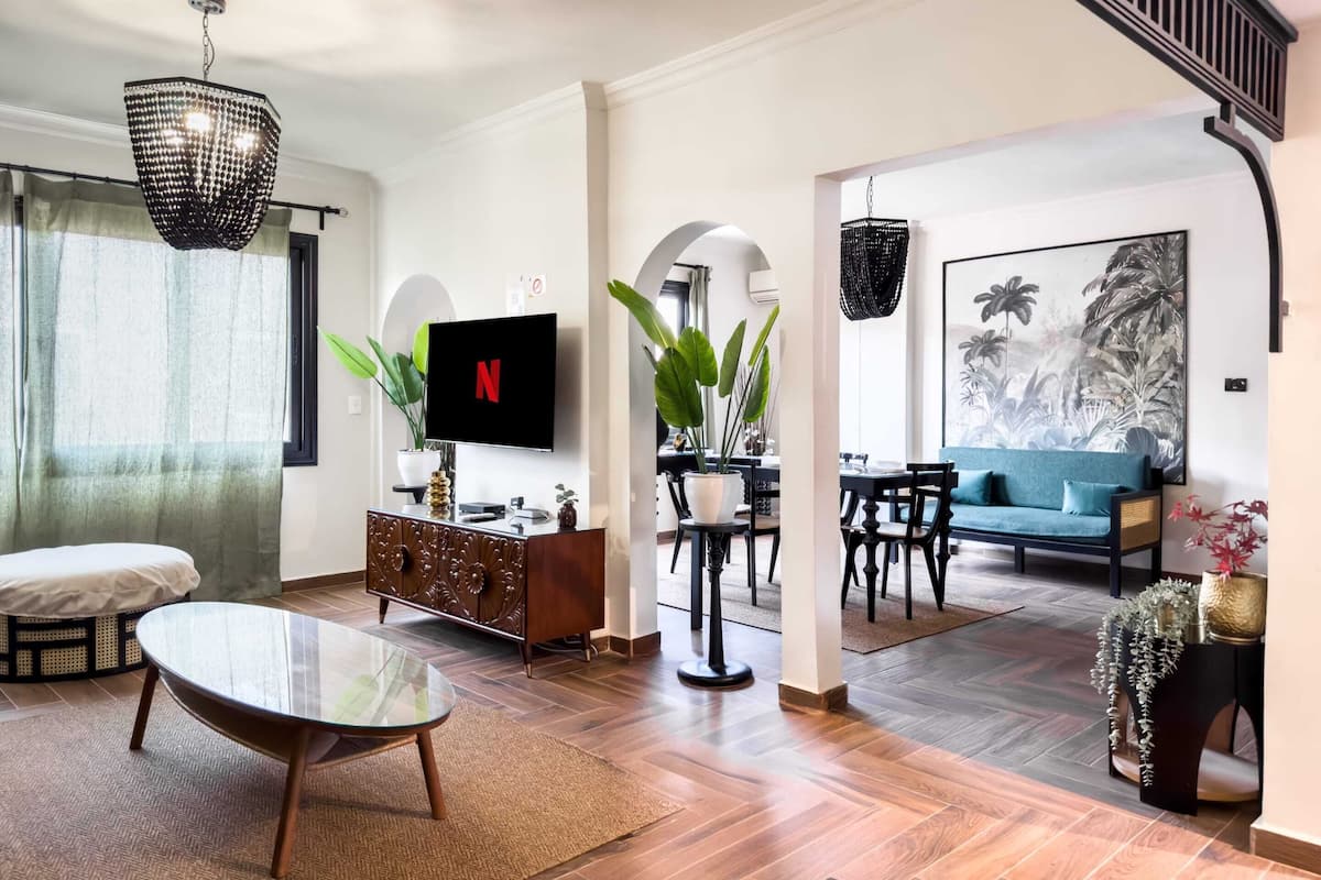 Ein modernes Wohnzimmer mit Flachbildfernseher, Essbereich und Sofa.
